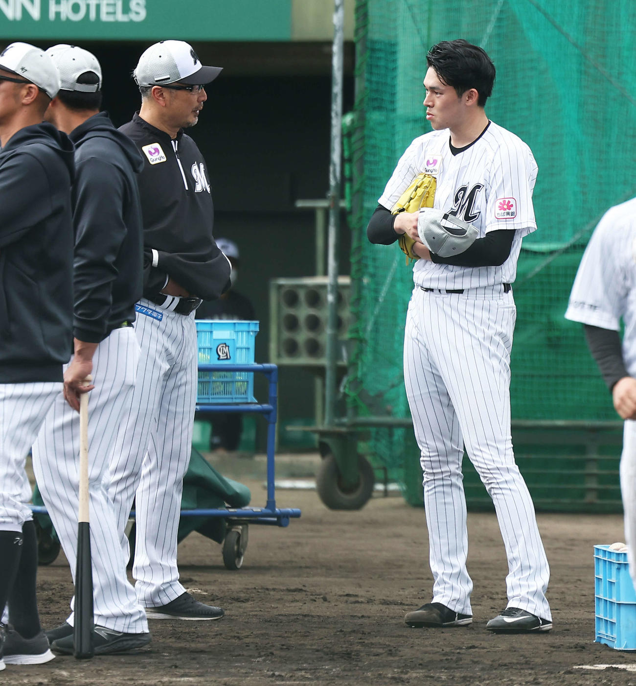 実戦形式の打撃練習後、吉井監督（左）と言葉を交わすロッテ佐々木朗（撮影・河田真司）