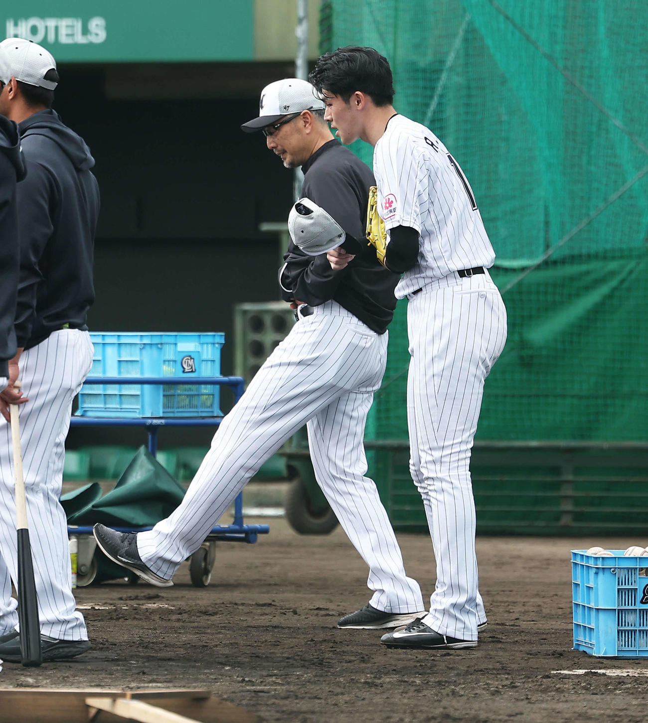 実戦形式の打撃練習後、吉井監督（左）と言葉を交わすロッテ佐々木朗（撮影・河田真司）