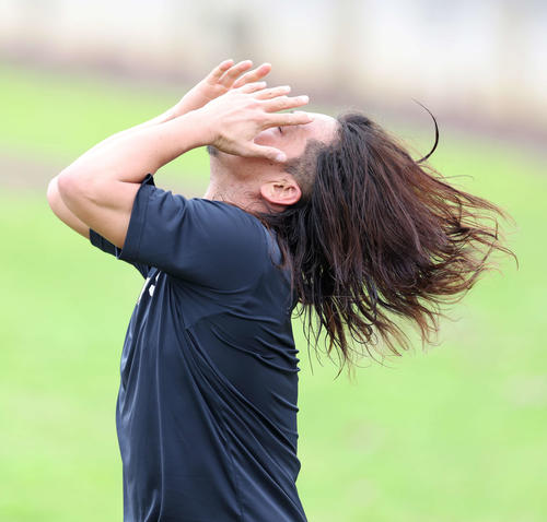 ブルペン投球を終え、ロングヘアをなびかせながら屋外に移動しコンディショニングに臨むロッテ沢村（撮影・河田真司）