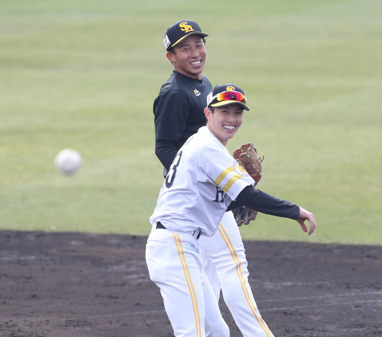 笑顔で送球を行う周東。後方は野村勇（撮影・屋方直哉）