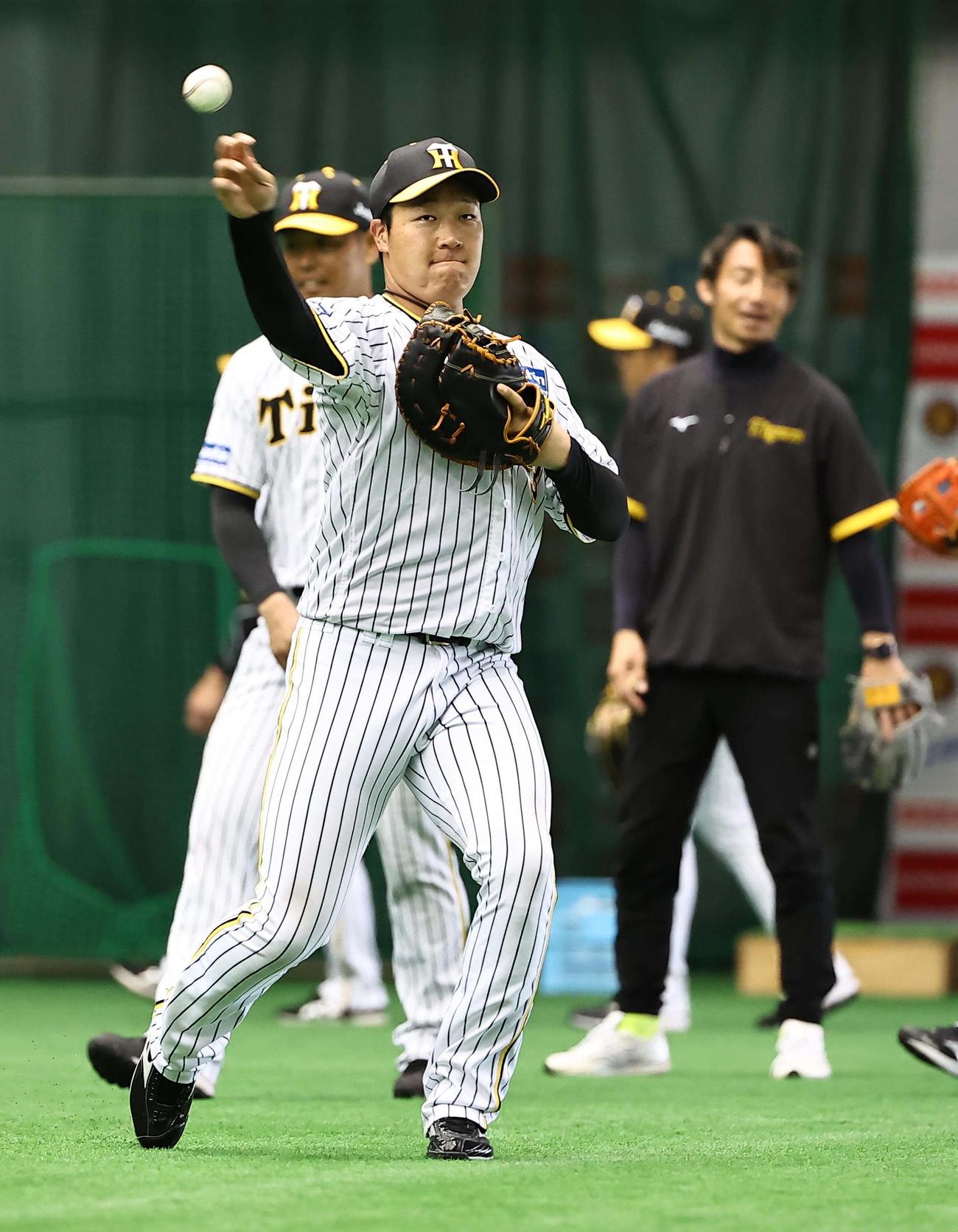 鳥谷臨時コーチ（右）のチェックを受けながらノックを受ける大山（撮影・上田博志）