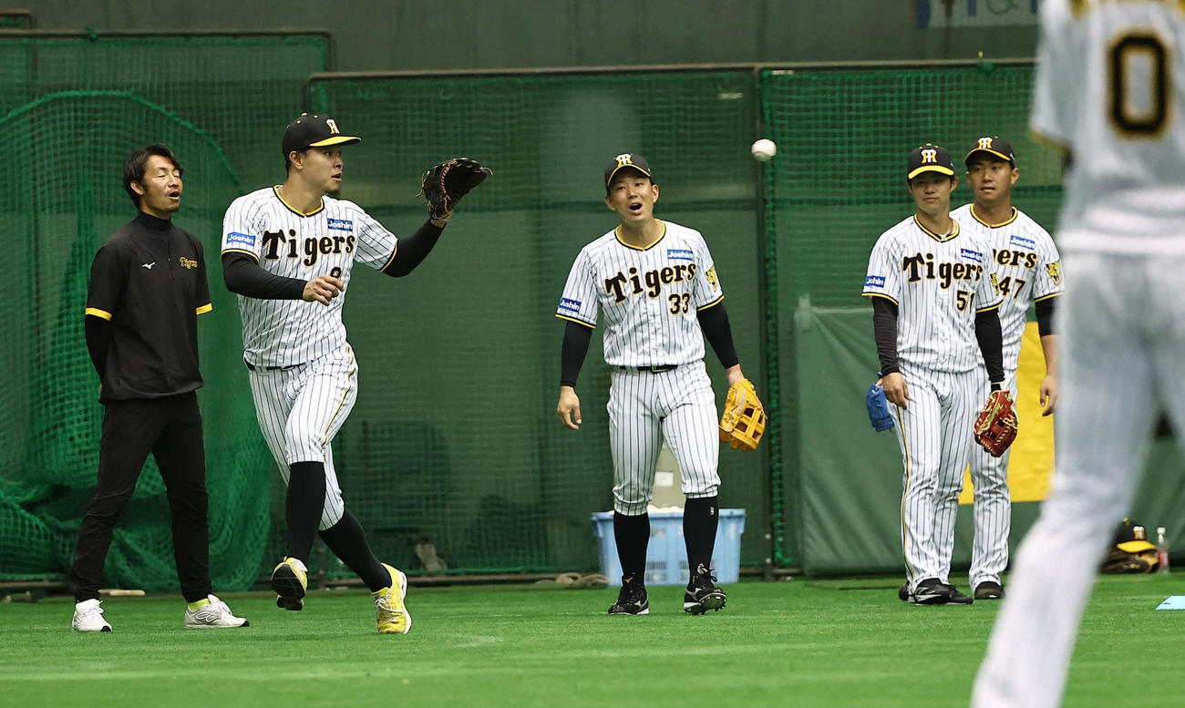 臨時コーチの鳥谷氏（左）は阪神ナインのボール回しを笑顔で見守る（撮影・上田博志）