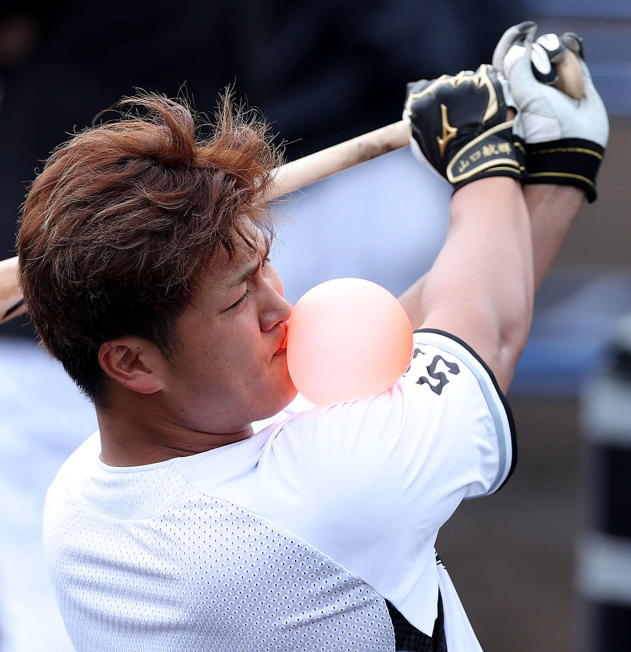 風船を膨らませながらトス打撃するロッテ山口（撮影・河田真司）