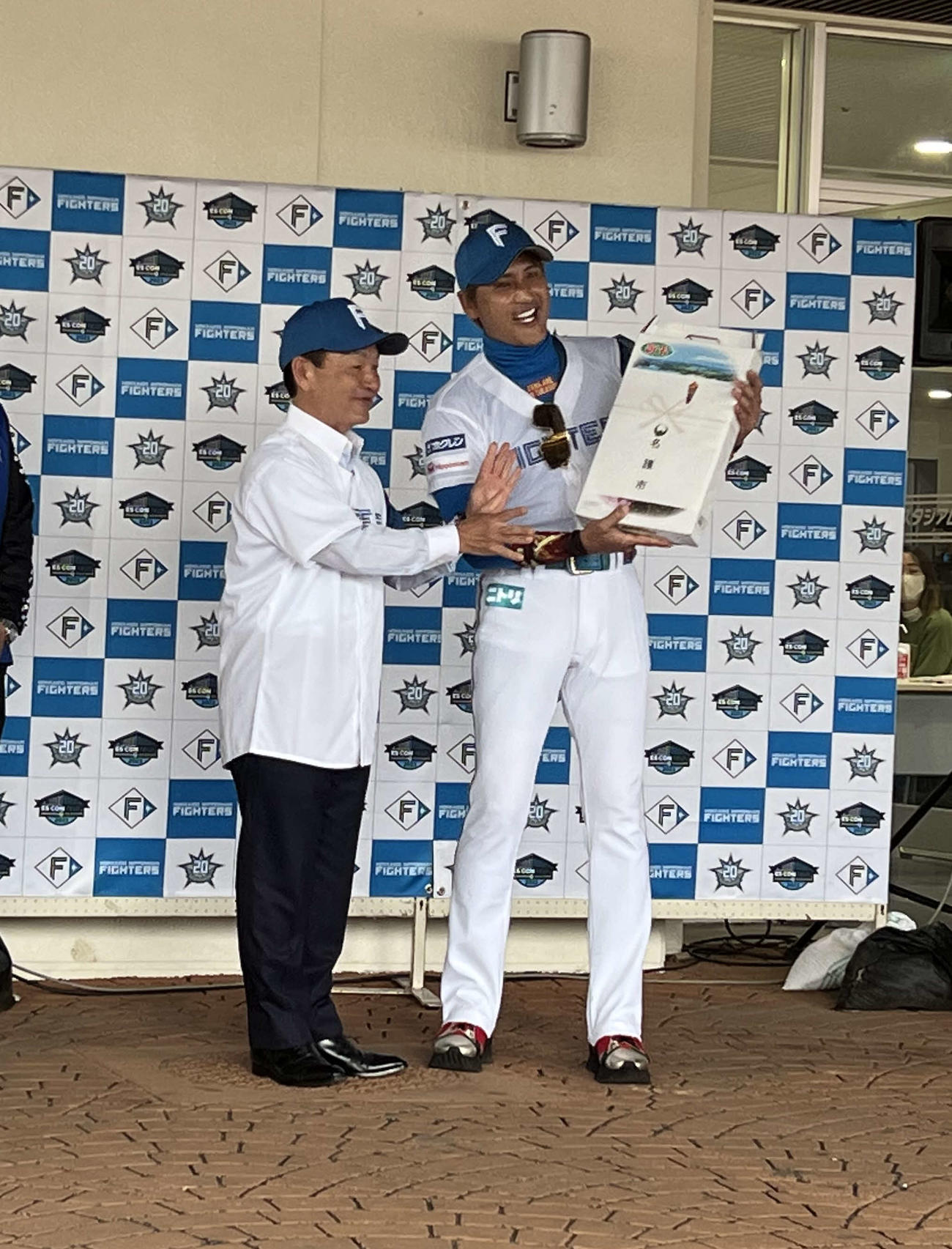 沖縄・名護市からの贈呈品を受け取り笑顔を浮かべる日本ハム新庄監督（撮影・中島宙恵）