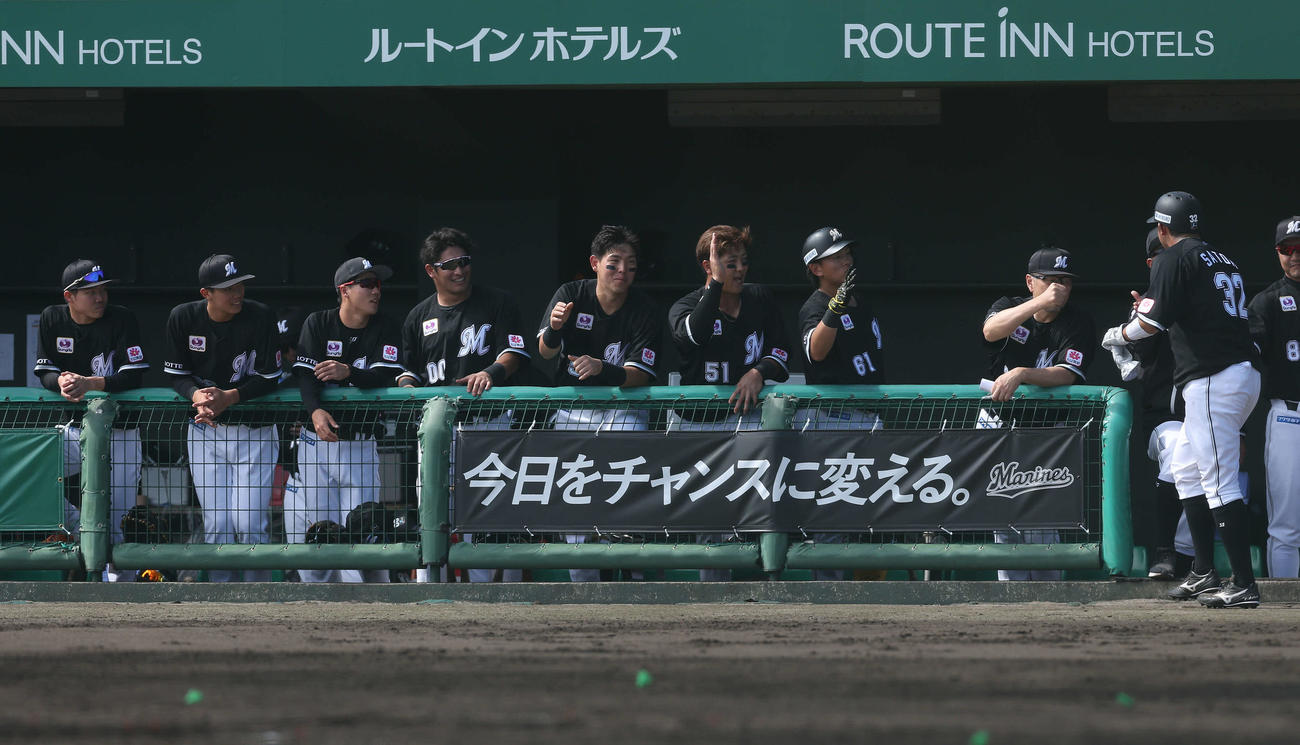 ロッテ対台湾楽天　2回表、村山の左越え先制適時二塁打で生還し、吉井監督（右から2人目）に迎えられるロッテ佐藤都（右）（撮影・河田真司）
