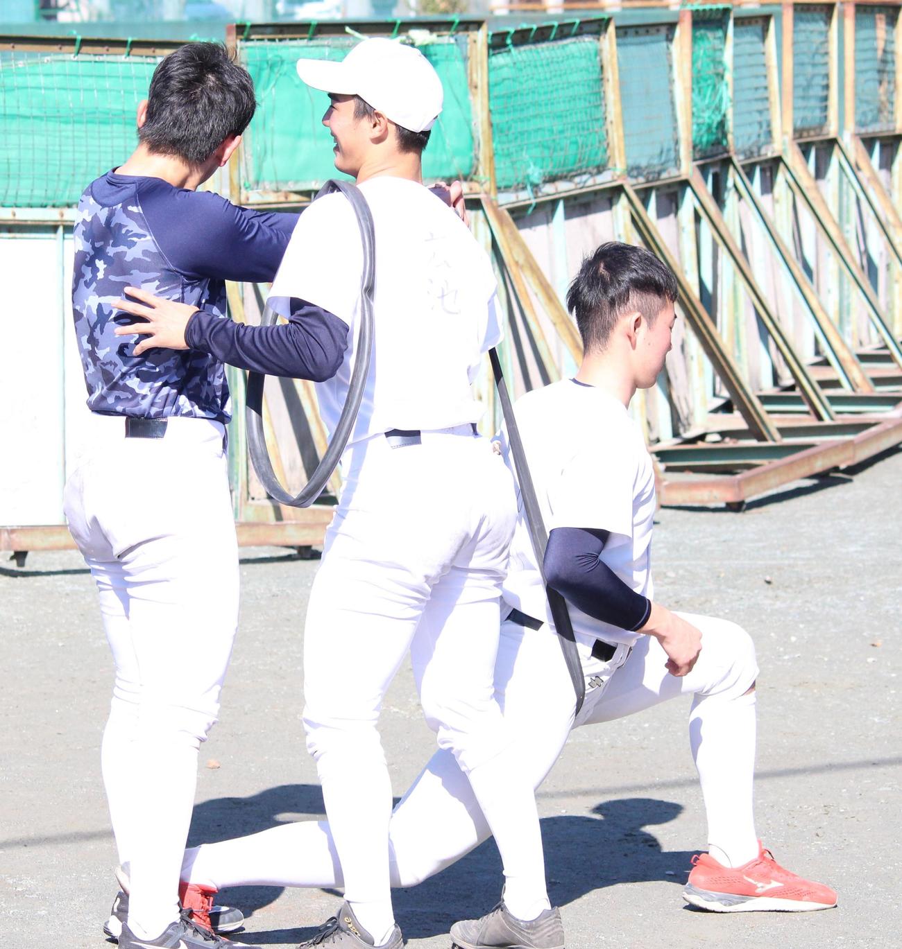 体幹トレーニングをする慶大の新入生、別所（右）と笑顔でサポートする広池（中央）（撮影・保坂恭子）