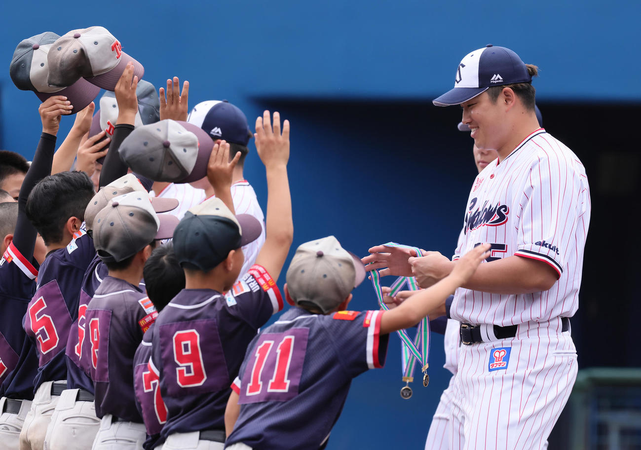 野球教室を終え、少年野球の表彰式で優勝メダルを子どもたちに渡すヤクルト村上（撮影・足立雅史）