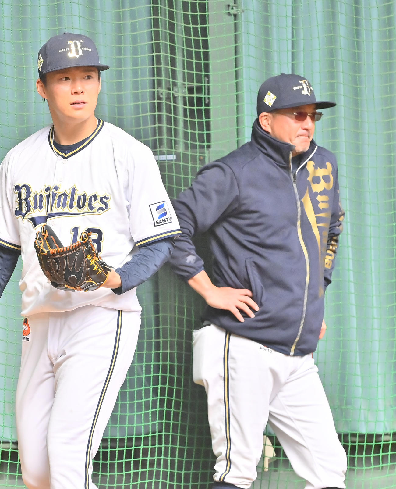 5日、ブルペンで投手陣をみるオリックス入来祐作コーチ、左は山本