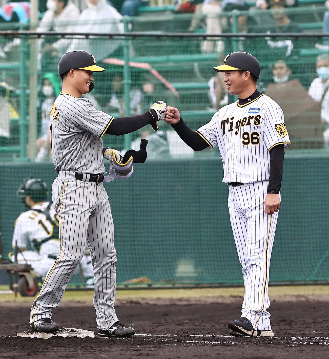 2軍紅白戦3回裏白組1死、二塁内野安打を放った森下（左）は筒井コーチと笑顔でグータッチをする（撮影・上田博志）