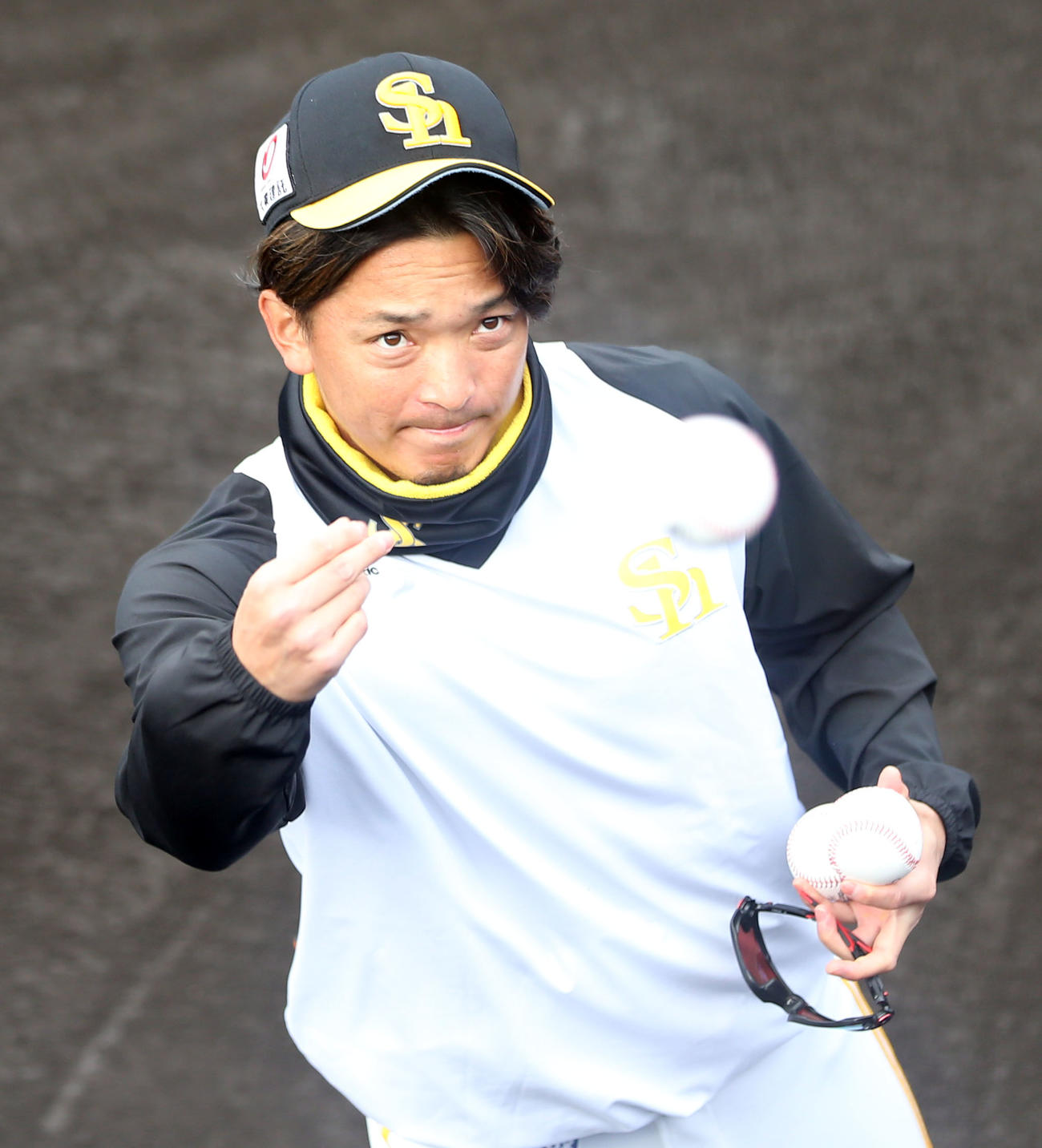 スタンドのファンに向け、サインボールを投げ入れる東浜（撮影・屋方直哉）