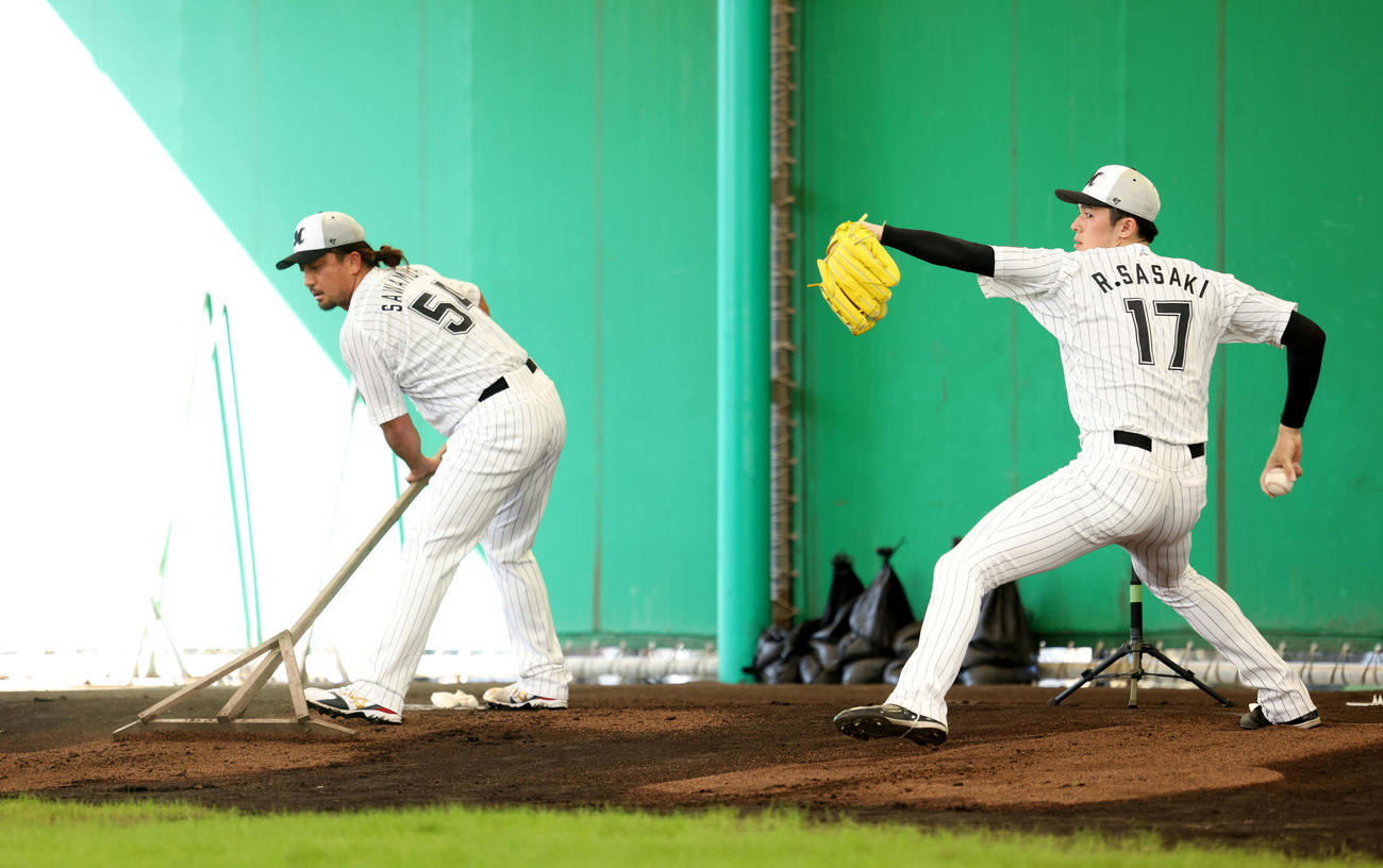 ブルペン投球するロッテ佐々木朗（右）と土をならす沢村（撮影・河田真司）