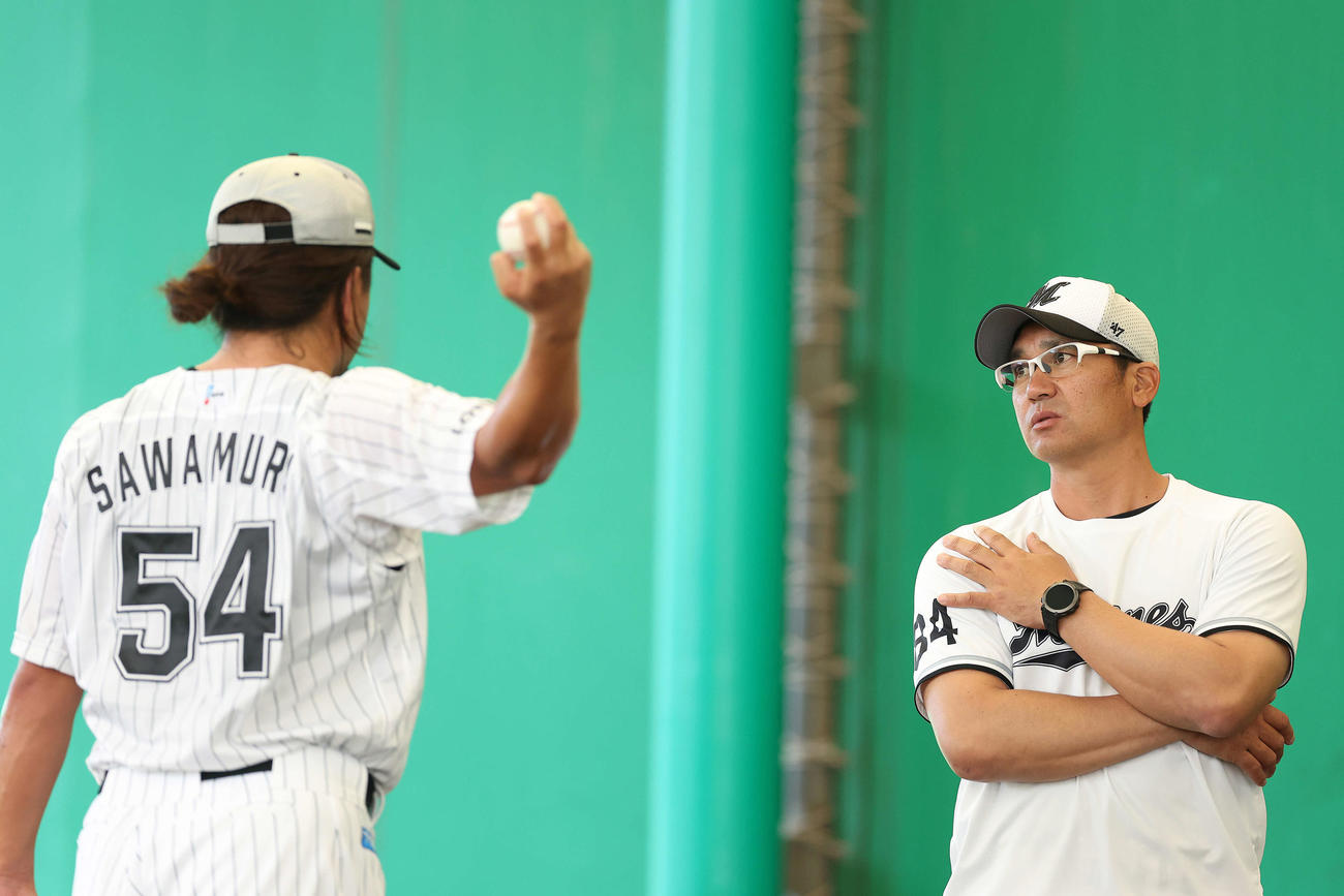 ブルペン投球を終え、ロッテ沢村（左）は黒木1軍投手コーチと言葉を交わす（撮影・河田真司）