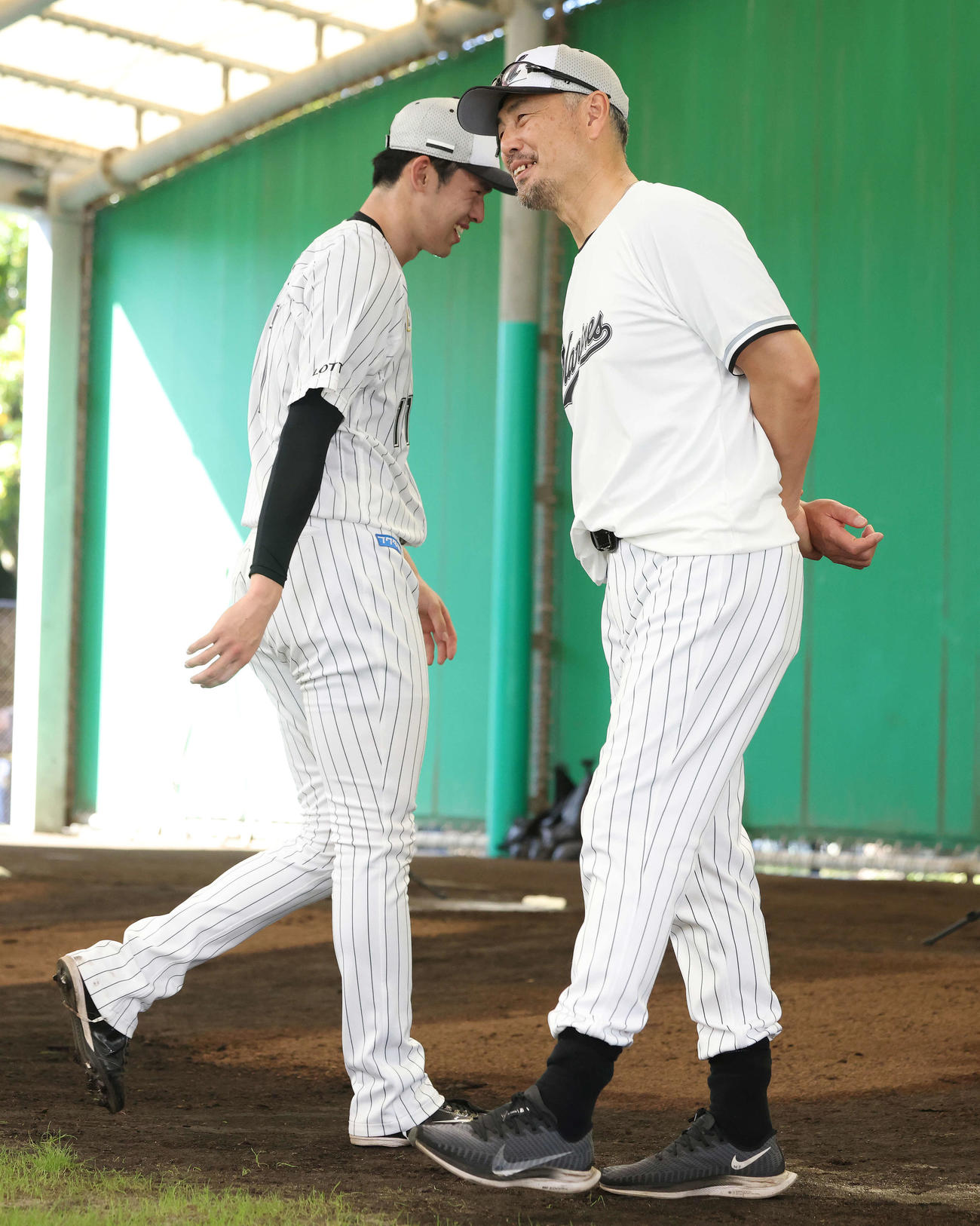ブルペン投球を終え、笑顔を見せるロッテ佐々木朗（左）と吉井監督（撮影・河田真司）