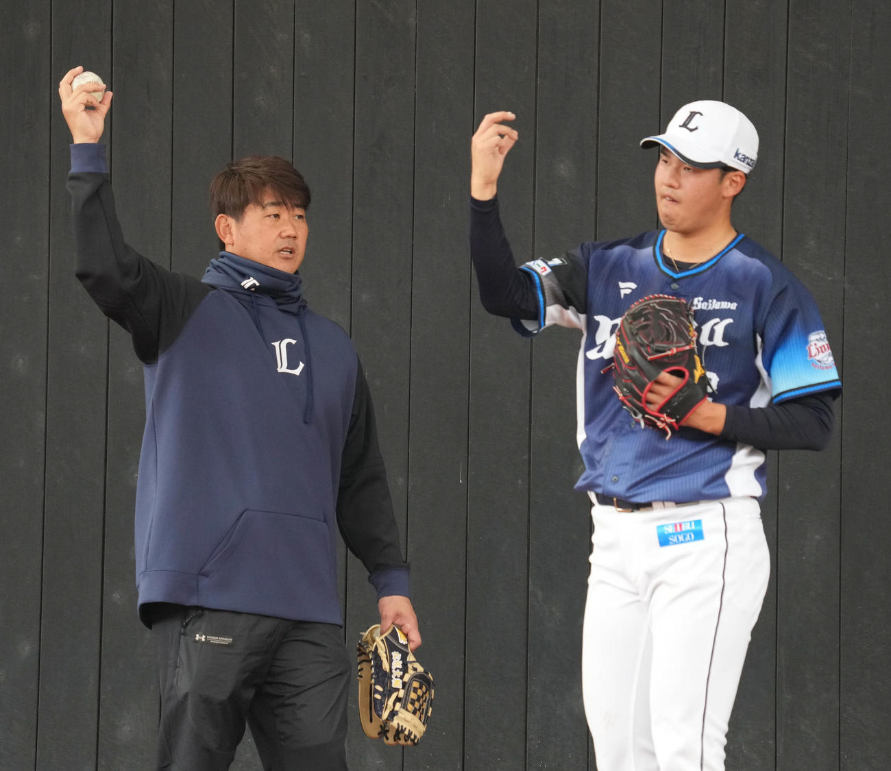 ブルペンで投球する渡辺（右）にスライダーを伝授する西武臨時投手コーチの松坂氏（撮影・小沢裕）