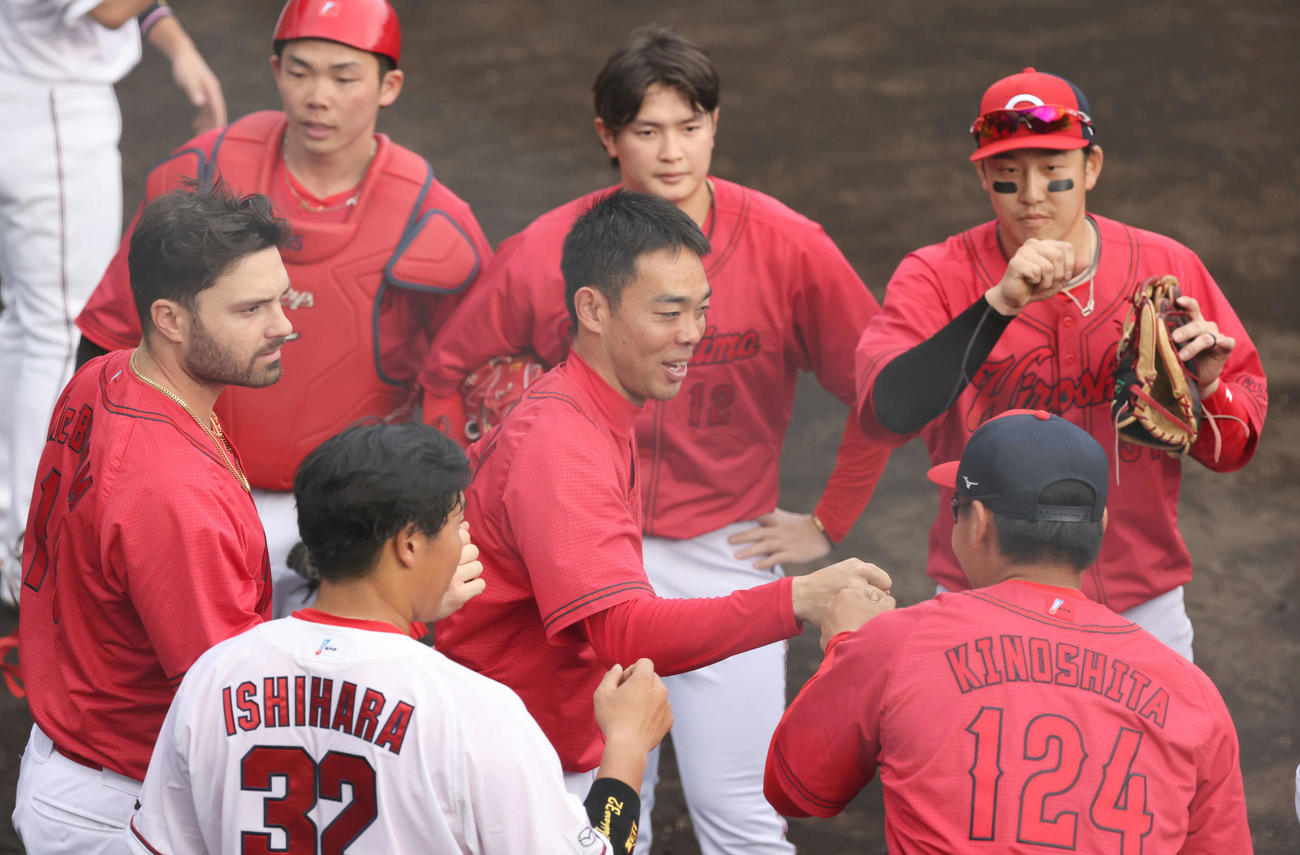 広島日南キャンプ　紅白戦　6回に右越え同点2点本塁打を放った秋山（中央）はナインとグータッチ（撮影・加藤孝規）