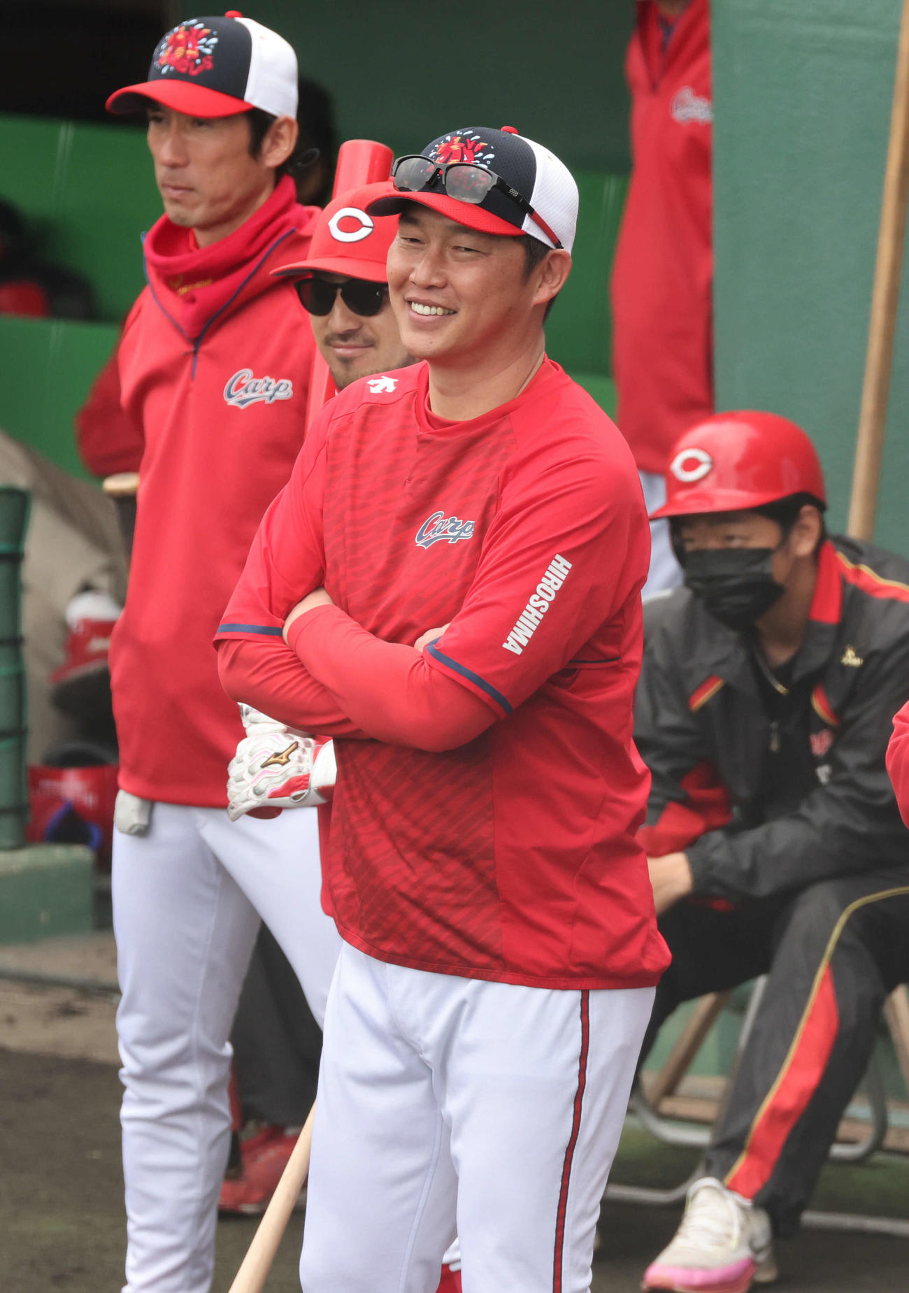 広島日南キャンプ　紅白戦　場内放送に笑みがこぼれる新井監督（中央）ら（撮影・加藤孝規）
