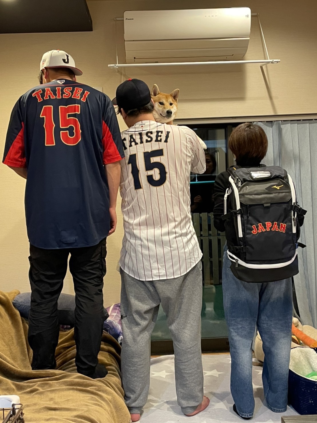 昨年11月の侍ジャパンシリーズで着用した日本代表のユニホームとリュックを着て記念撮影する翁田3兄姉。左から巨人大勢、兄勝基さん、姉あかりさん（母いずみさん提供）