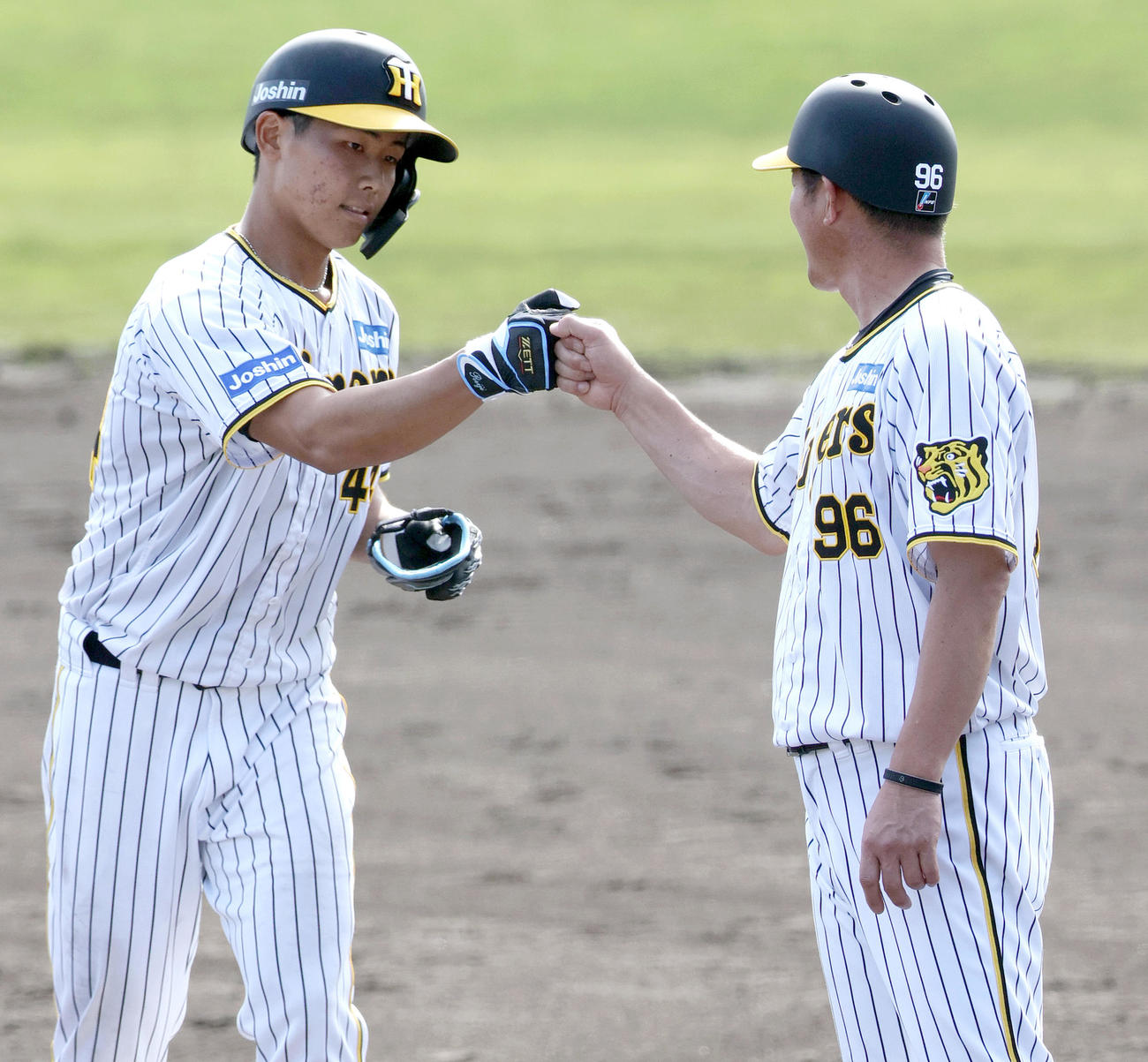 紅白戦　9回裏白組1死、戸井は右前打を放ち筒井コーチとグータッチする（撮影・上山淳一）