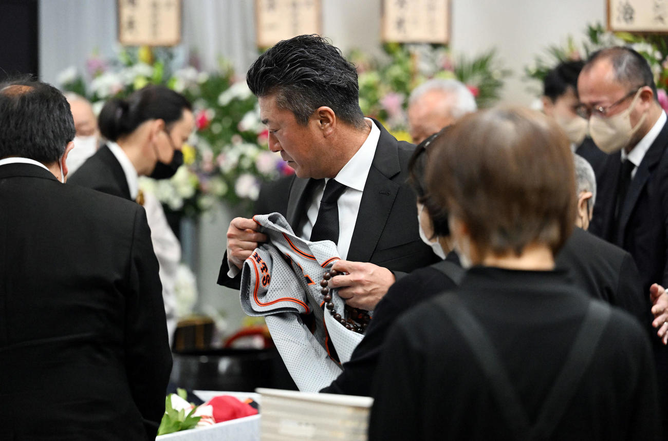 入来智さんの葬儀・告別式で思い出の品を棺に入れる弟のオリックス祐作投手コーチ（撮影・滝沢徹郎）