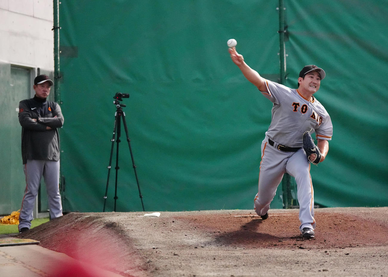 巨人原監督（左）が見つめる中、ブルペンで力投する菅野（撮影・江口和貴）