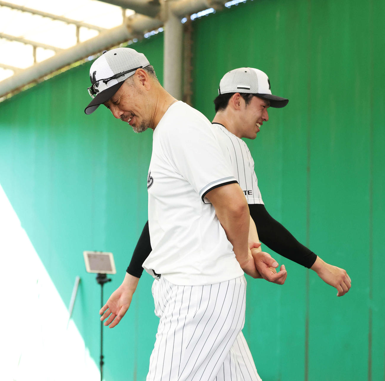 12日、ブルペン投球を終え、吉井監督（手前）と笑顔で言葉を交わす佐々木朗
