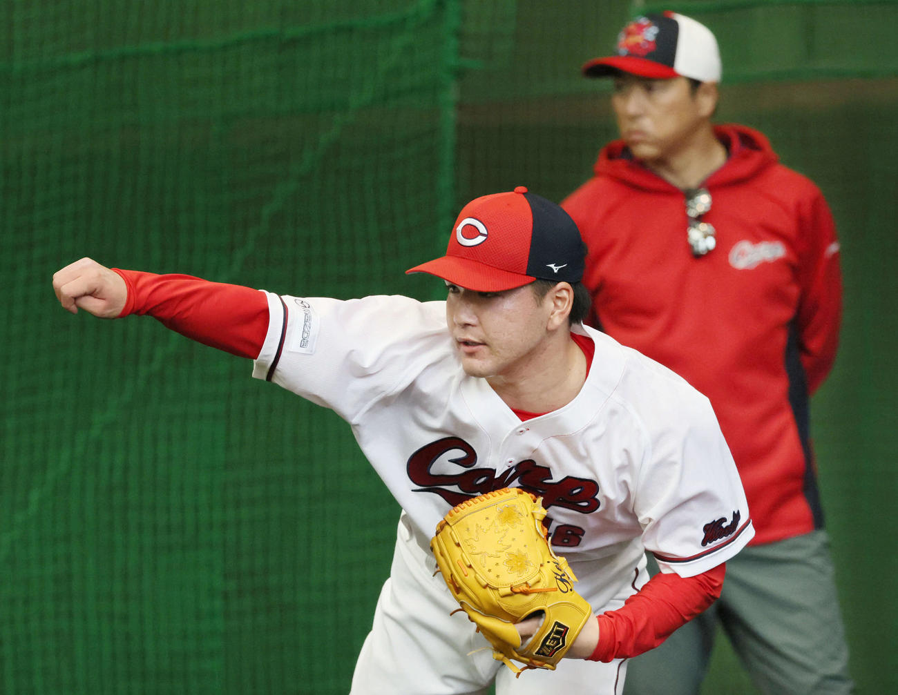 広島日南キャンプ　ブルペンで投げるドラフト5位の河野と見守る黒田球団アドバイザー（右後ろ）（撮影・加藤孝規）