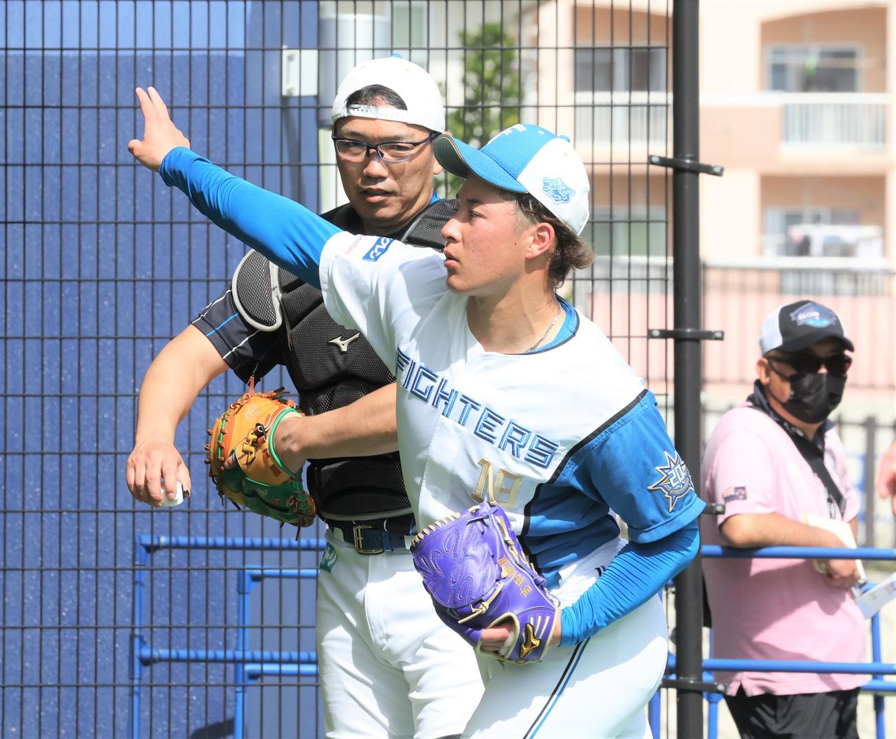 ブルペンで投球後、捕手と話す日本ハム吉田（撮影・黒川智章）