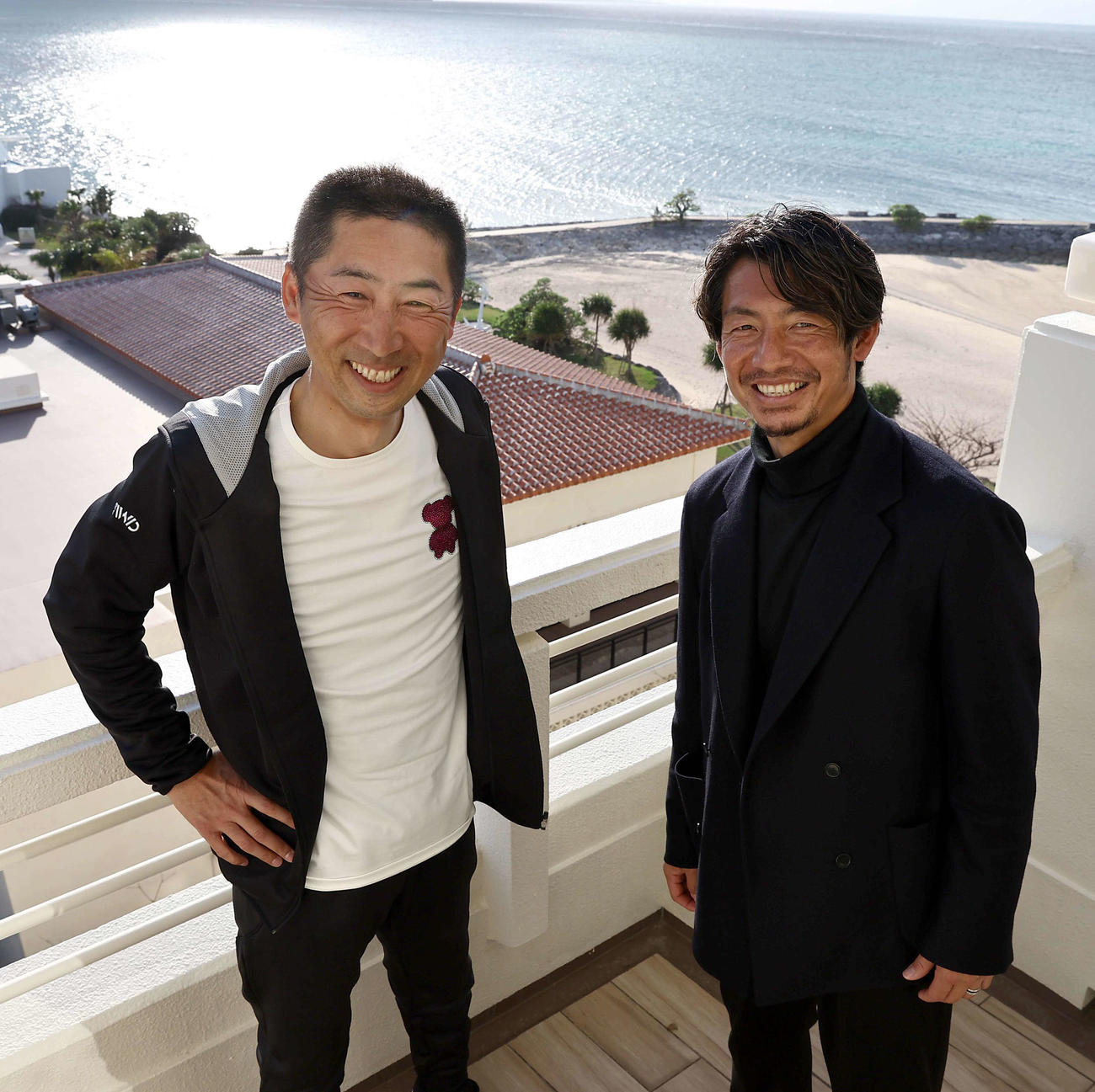 沖縄の海を背に笑顔を見せる阪神今岡コーチ（左）と本紙評論家の鳥谷氏（撮影・上田博志）