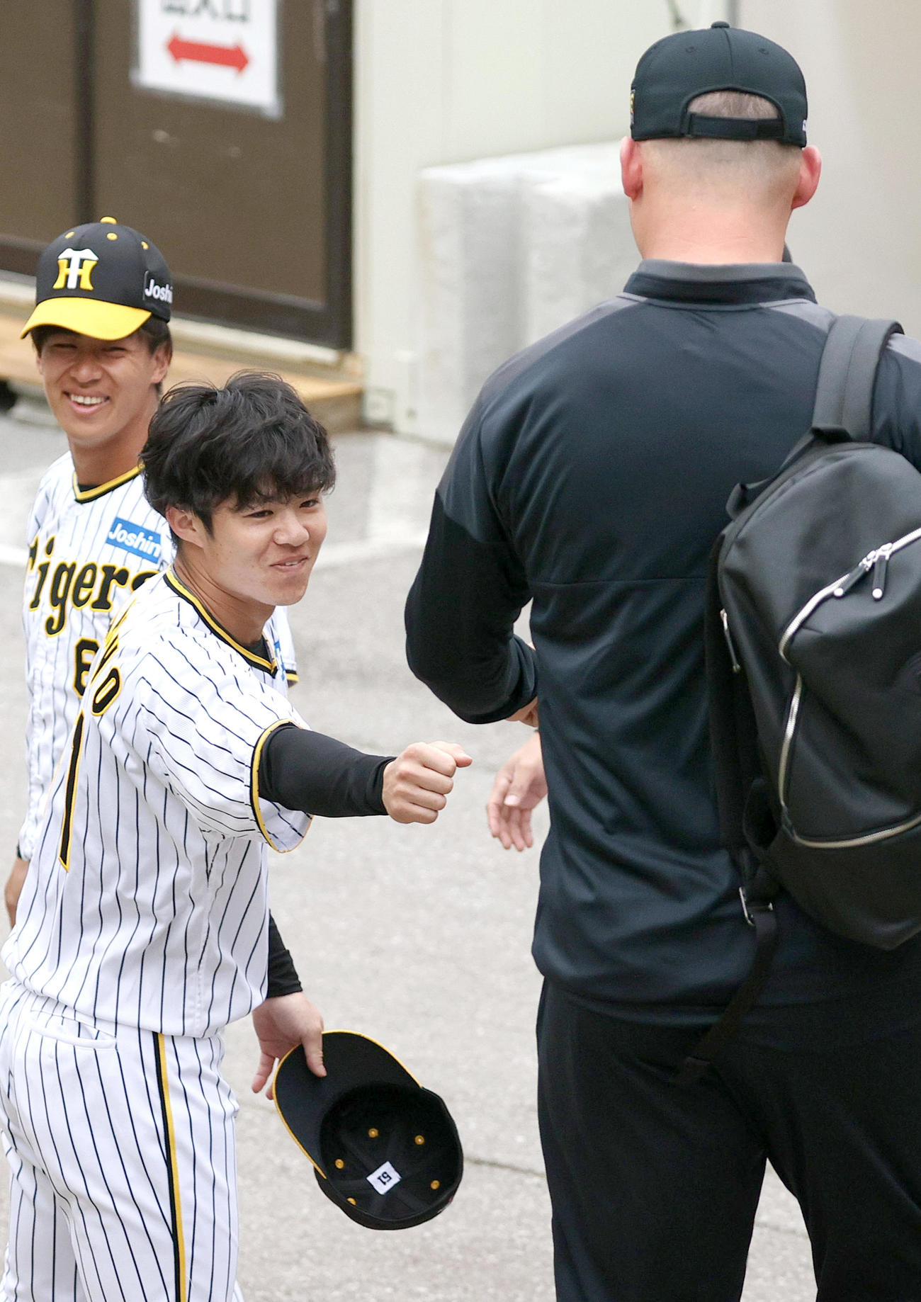 宜野座村野球場に訪れたサンズ駐米スカウト（右）とタッチを交わす中野（左から2人目）ら（撮影・上山淳一）