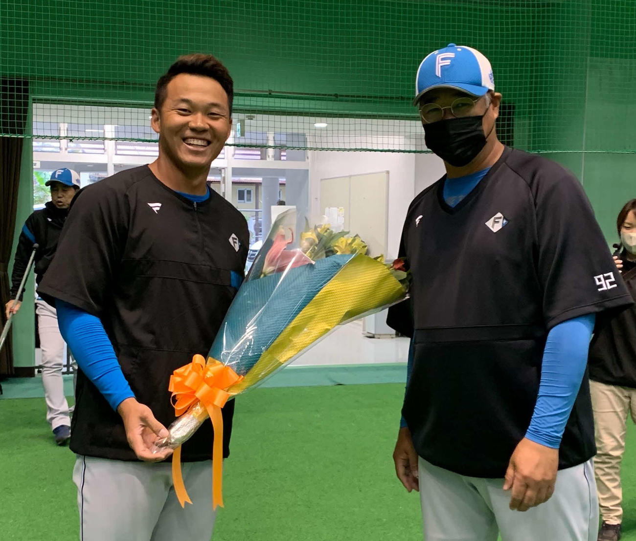 WBC出場のため日本ハム木田優夫2軍監督（右）から花束を受け取る王（球団提供）
