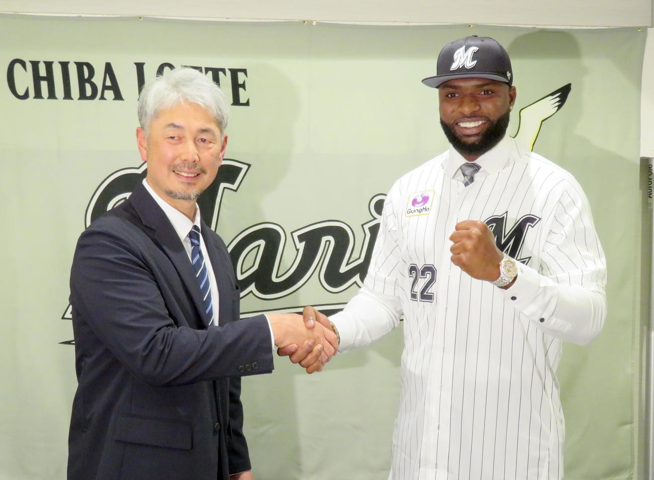 吉井監督（左）と握手を交わして活躍を誓うロッテ新外国人ポランコ（撮影・鎌田直秀）
