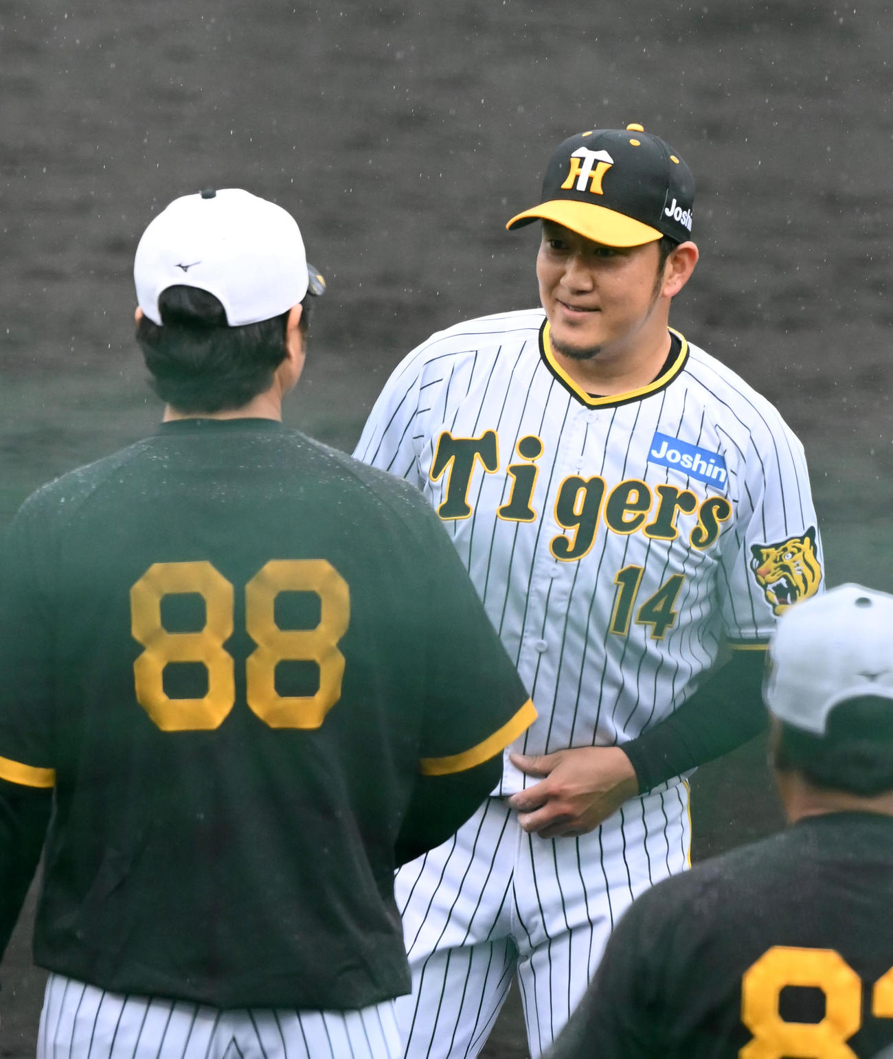 フリー打撃に登板した岩貞（右）は安藤コーチと笑顔で話す（撮影・前岡正明）