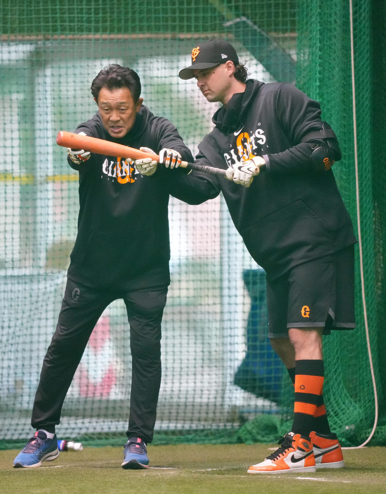 早朝練習で巨人川相総合コーチ（左）からバントの指導を受けるビーディ（23年2月3日撮影）