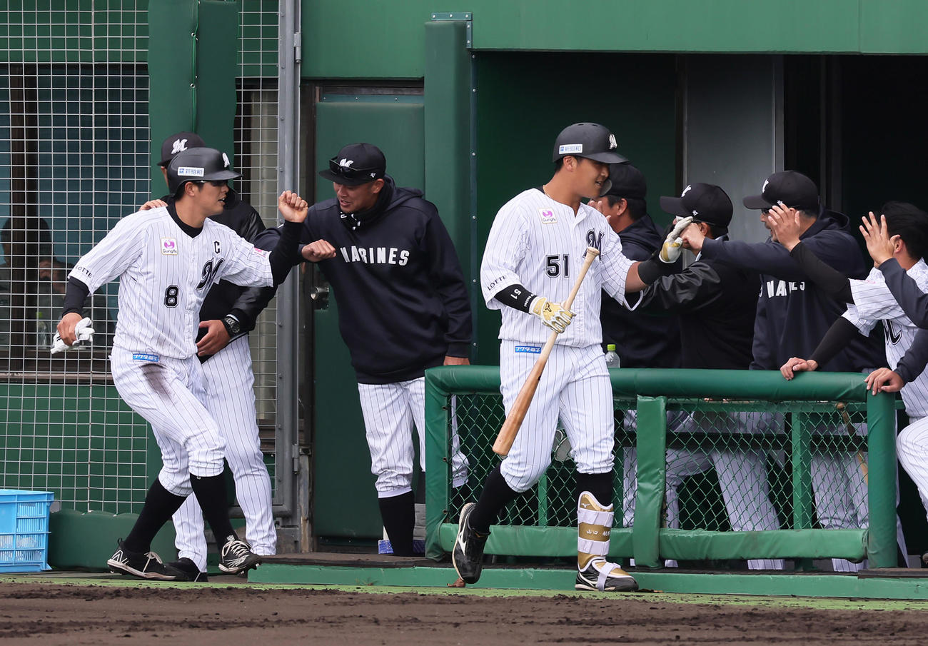 ロッテ対ヤクルト　1回裏ロッテ1死一塁、山口（手前右）は左中間へ2点本塁打を放ち吉井監督（右から2人目）らにタッチで迎えられる（撮影・足立雅史）