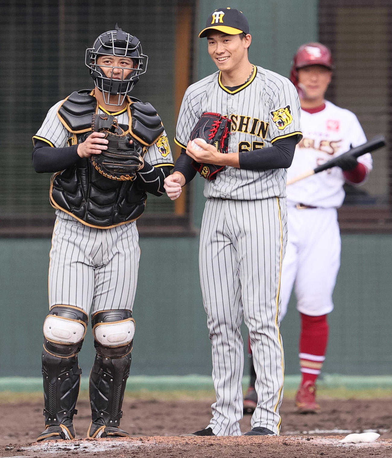 練習試合・楽天対阪神　4回裏楽天2死一、二塁、湯浅京己（中央）は捕手坂本誠志郎と笑顔で話す（撮影・上山淳一）