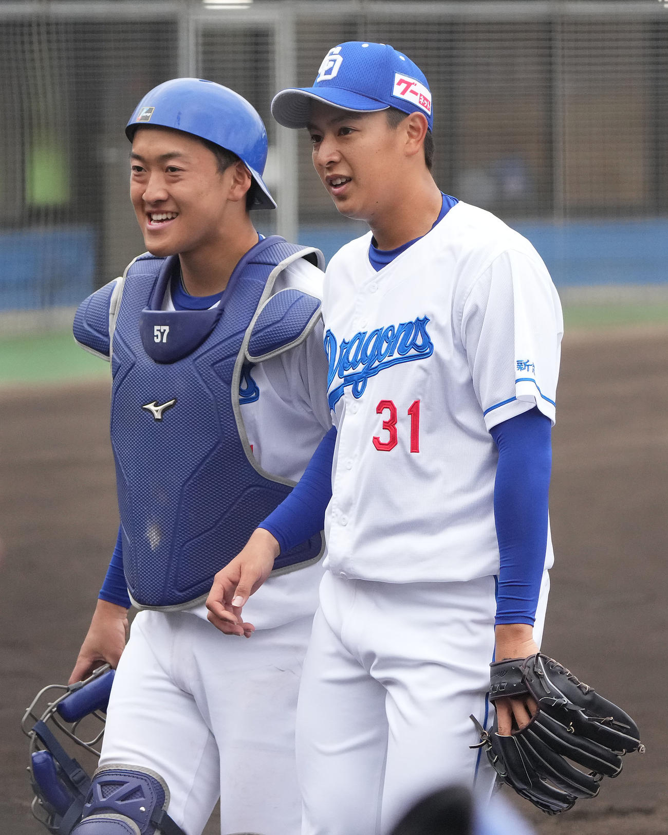 沖縄電力戦に先発した中日仲地は山浅（右）と笑顔でベンチへ戻る（撮影・森本幸一）