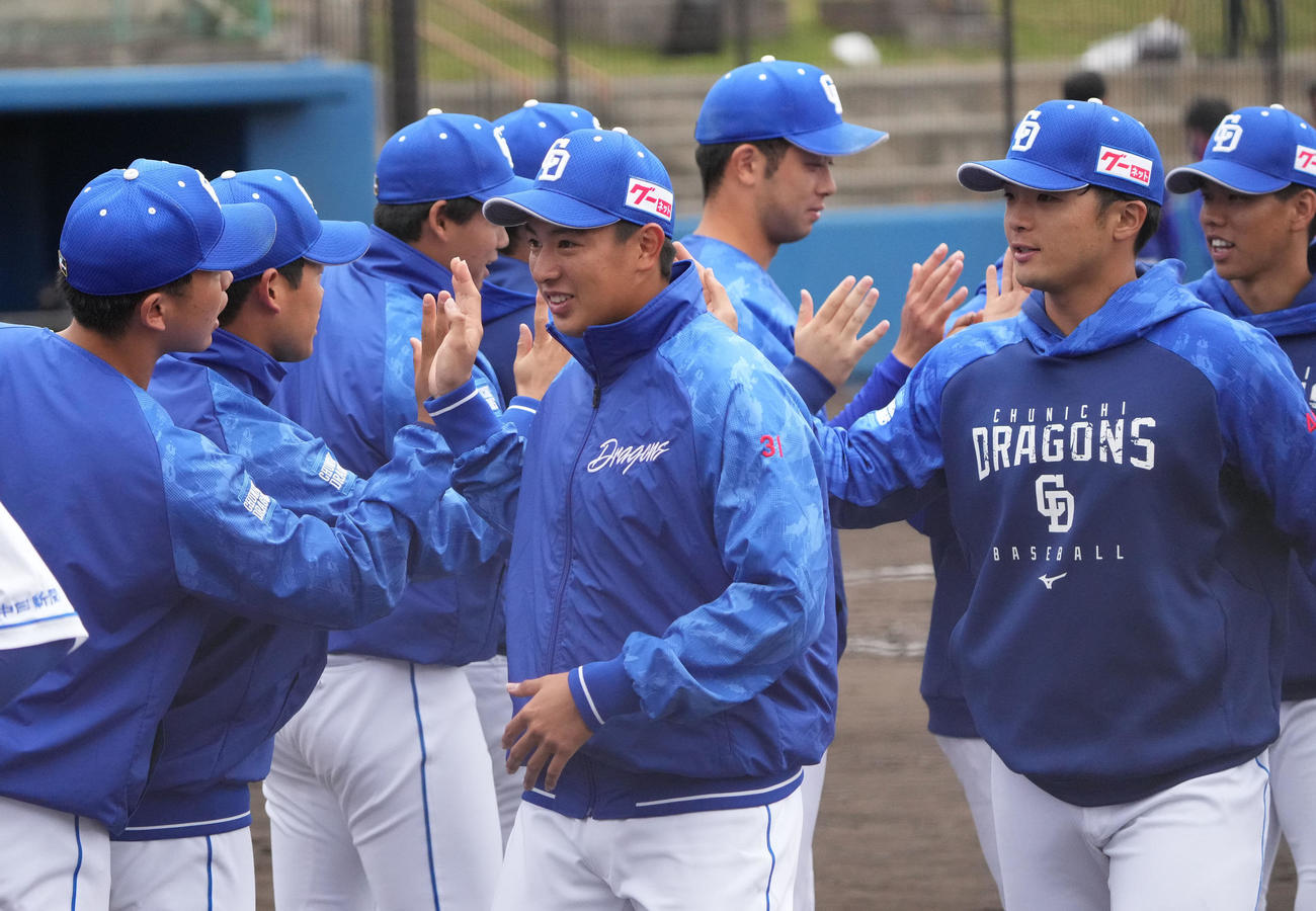 中日2軍練習試合　中日対沖縄電力　試合終了、ナインとタッチを交わす仲地（中央）（撮影・森本幸一）