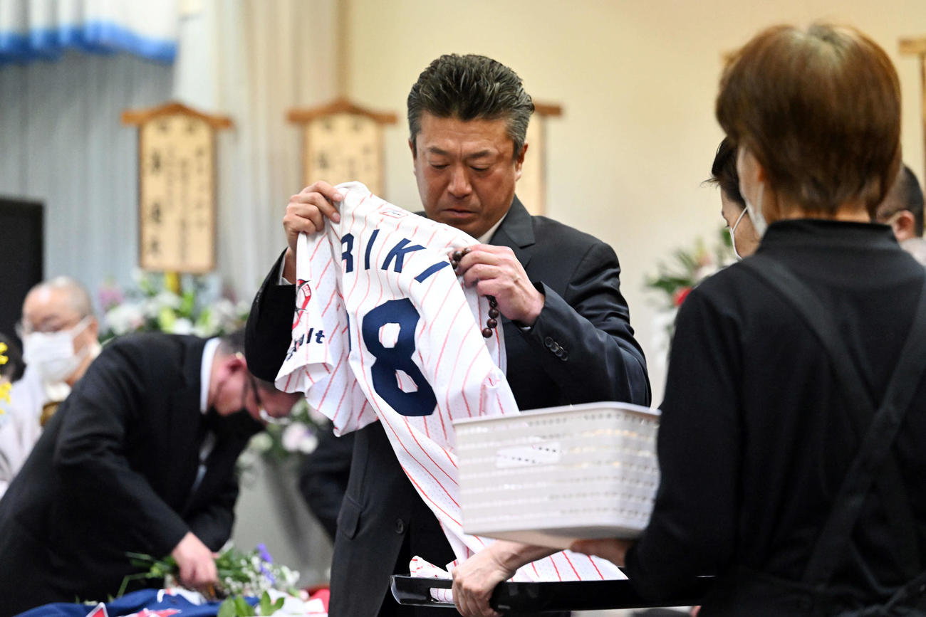 入来智さんの葬儀・告別式で思い出の品をひつぎに入れる弟のオリックス入来祐作投手コーチ（撮影・滝沢徹郎）
