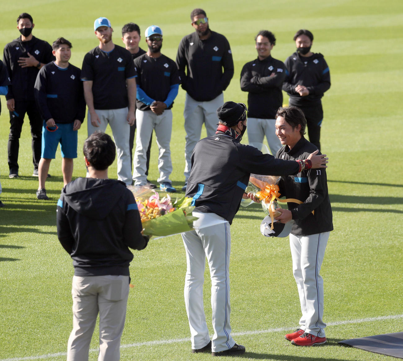 日本ハム新庄監督（中央）から花束を贈呈される伊藤（右）（撮影・佐藤翔太）