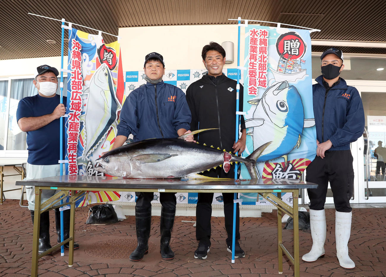 マグロを贈呈され笑顔で撮影に応じる日本ハム稲葉GM（撮影・佐藤翔太）