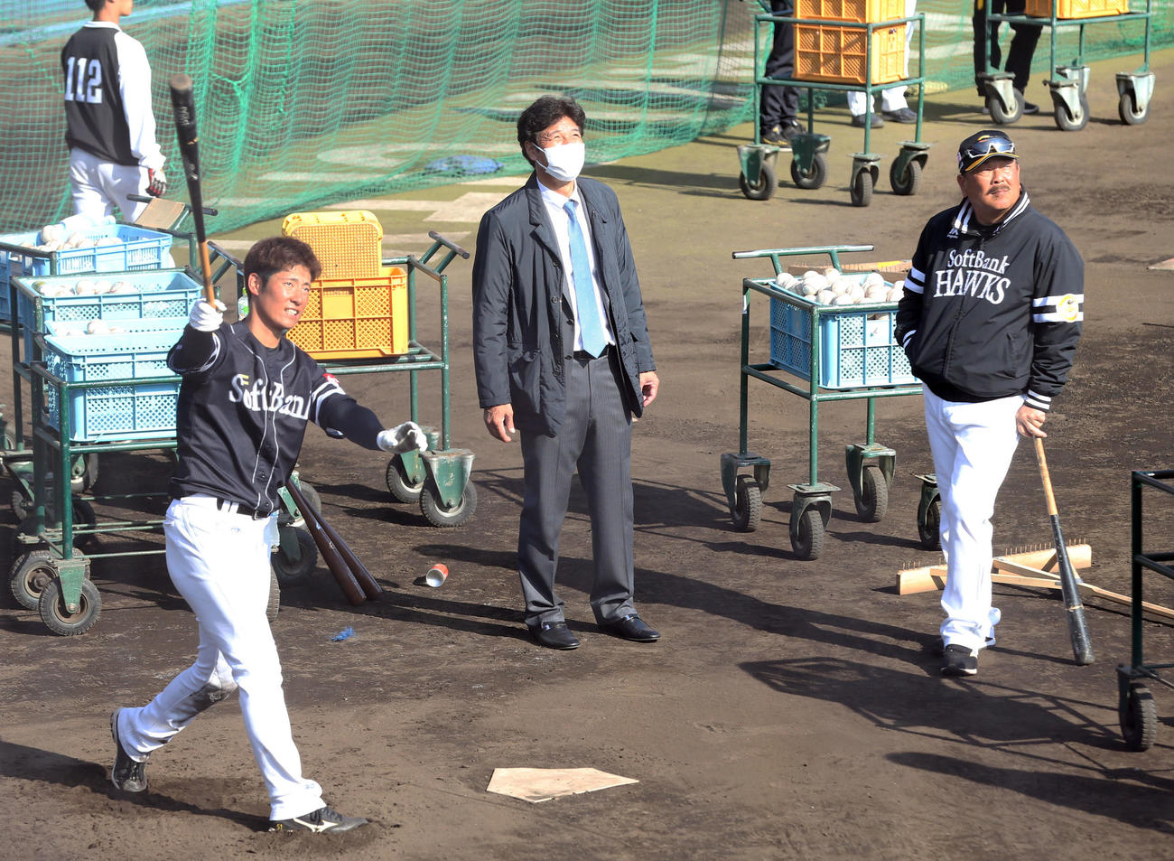 秋山氏（中央）と藤本監督（右）に見守られながら特打を行う上林（撮影・屋方直哉）