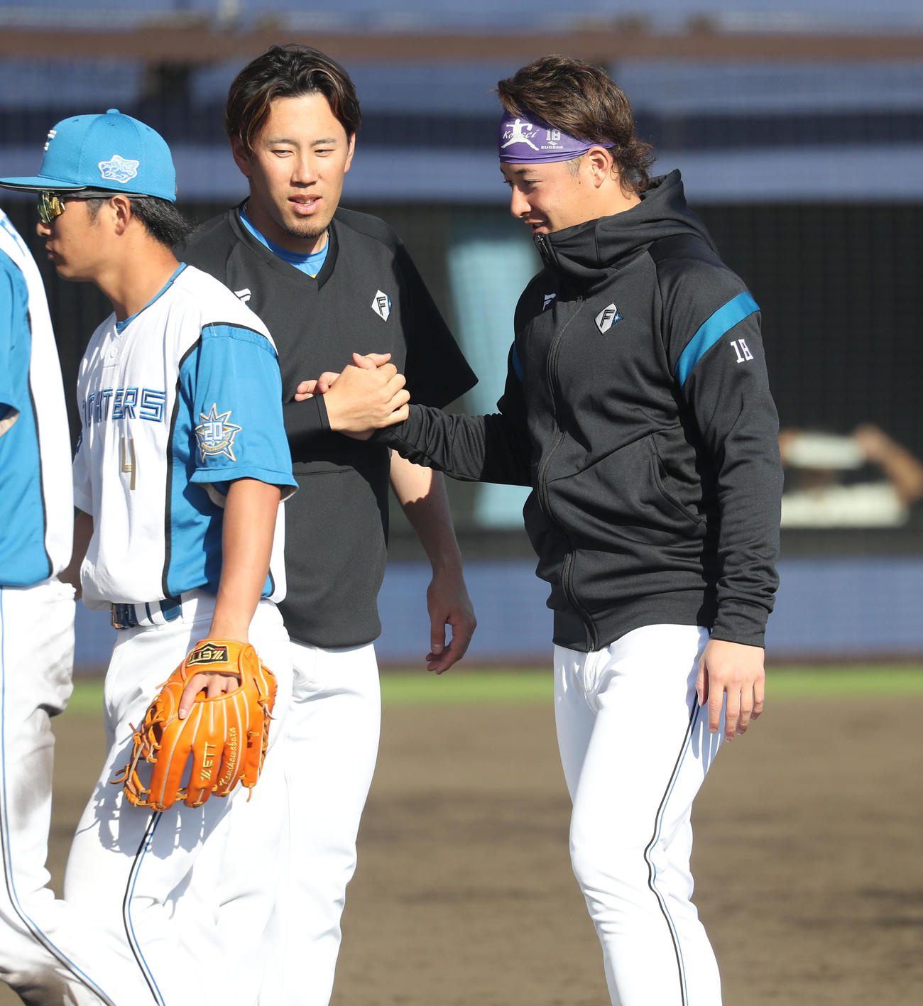 日本ハム対キューバ　握手を交わしながら引き揚げる日本ハム西村（左）と吉田（撮影・佐藤翔太）