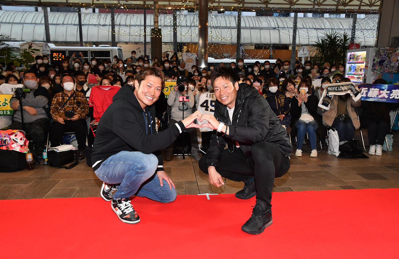 トークショーを終え、集まったファンを背にハートをつくる阿部（左）と近藤（撮影・岩下翔太）