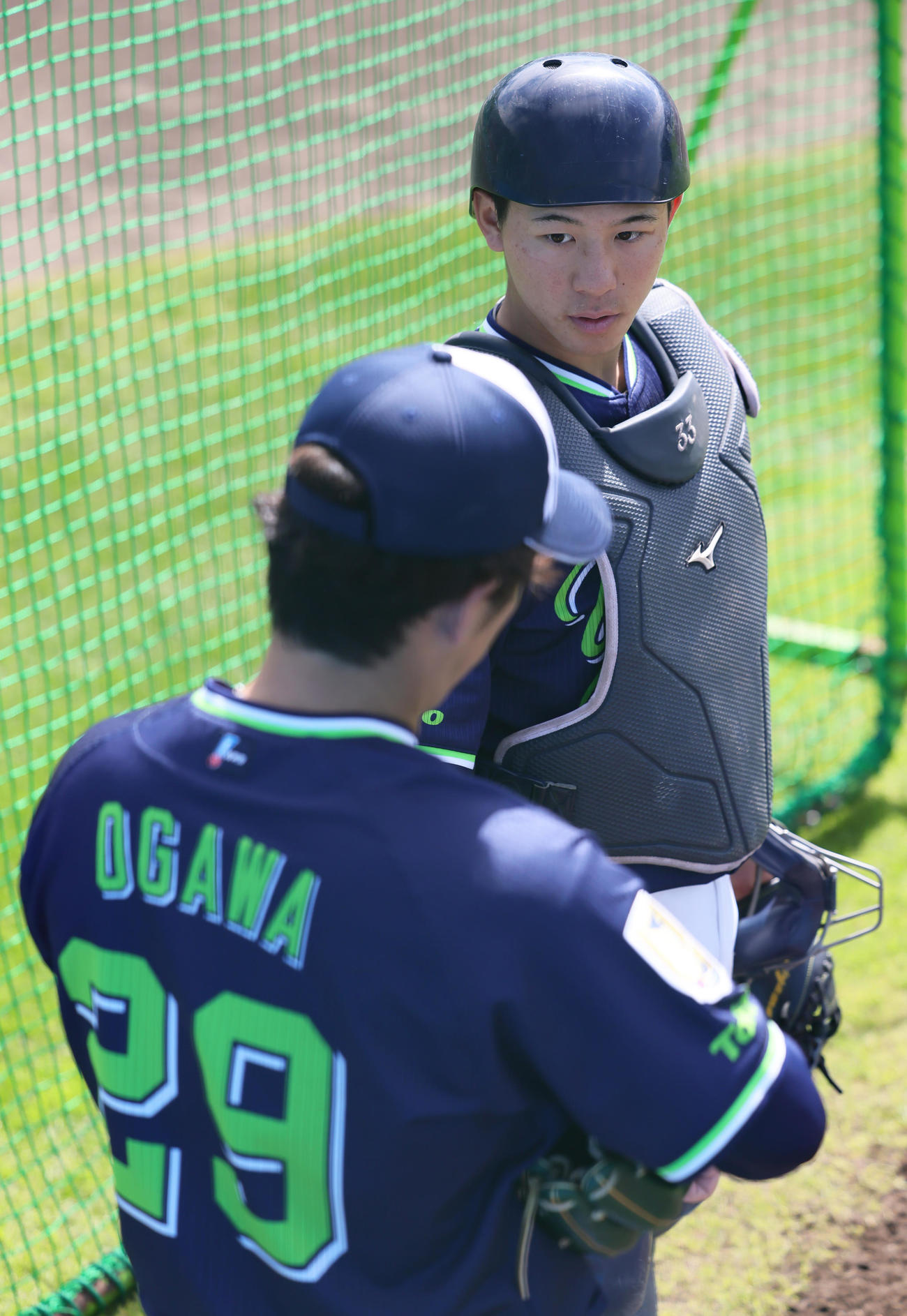 ブルペンで会話を交わす内山（後方）と小川（撮影・足立雅史）