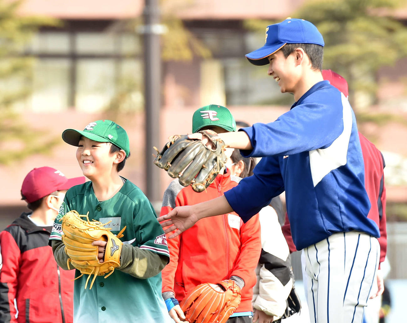 野球教室で笑顔を見せる参加者と東北学院榴ケ岡の部員（撮影・相沢孔志）