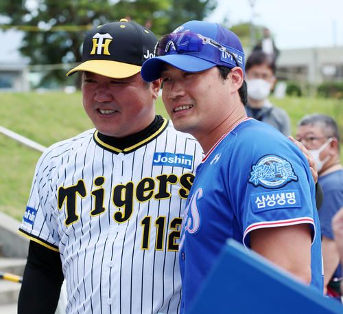 阪神対サムスン 笑顔で片山ブルペン捕手(左)と記念写真に納まる呉昇桓(撮影・加藤哉)