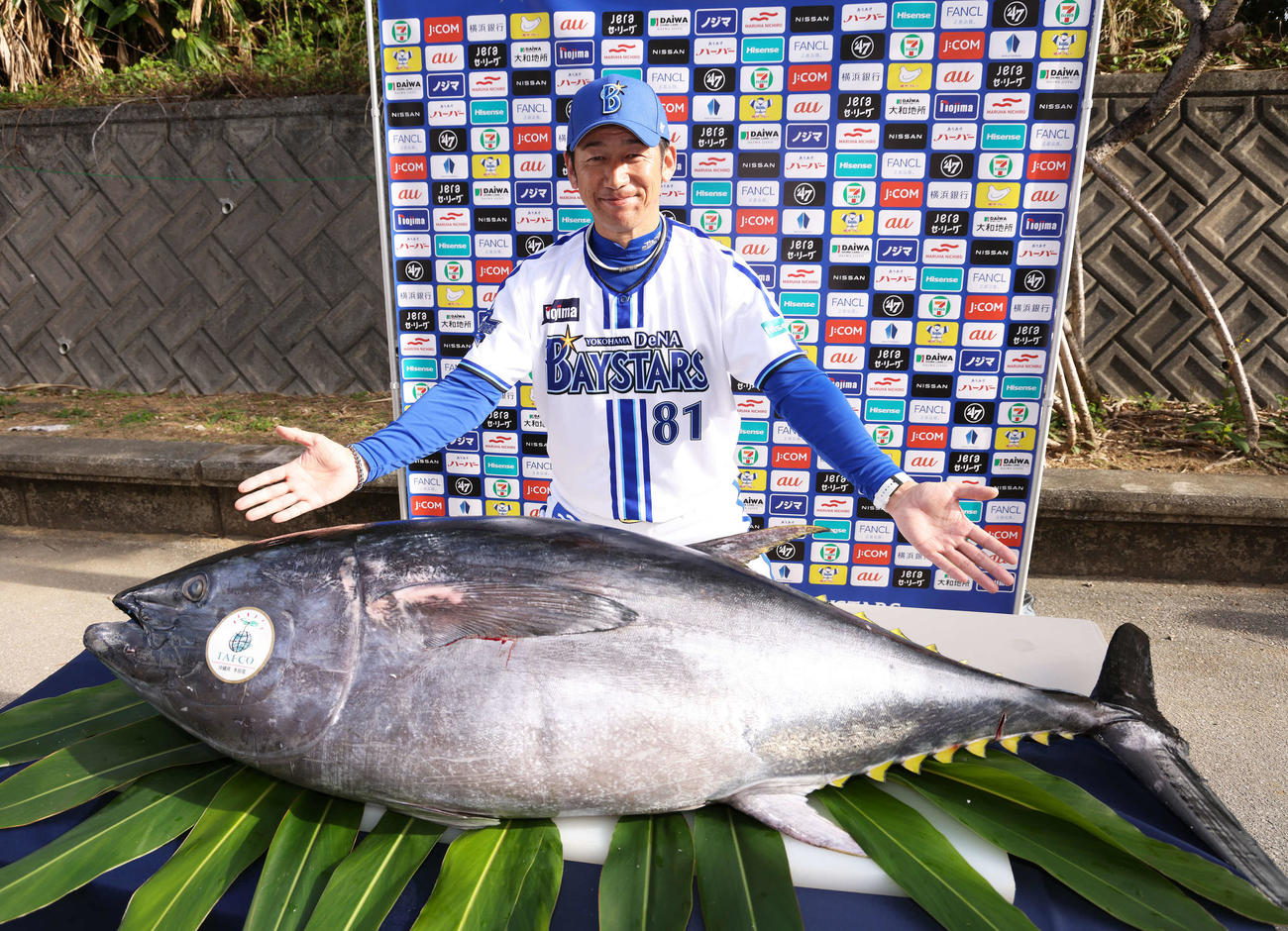 マルハニチロから養殖クロマグロが贈呈され、両手を広げ写真に納まるDeNA三浦監督（撮影・河田真司）