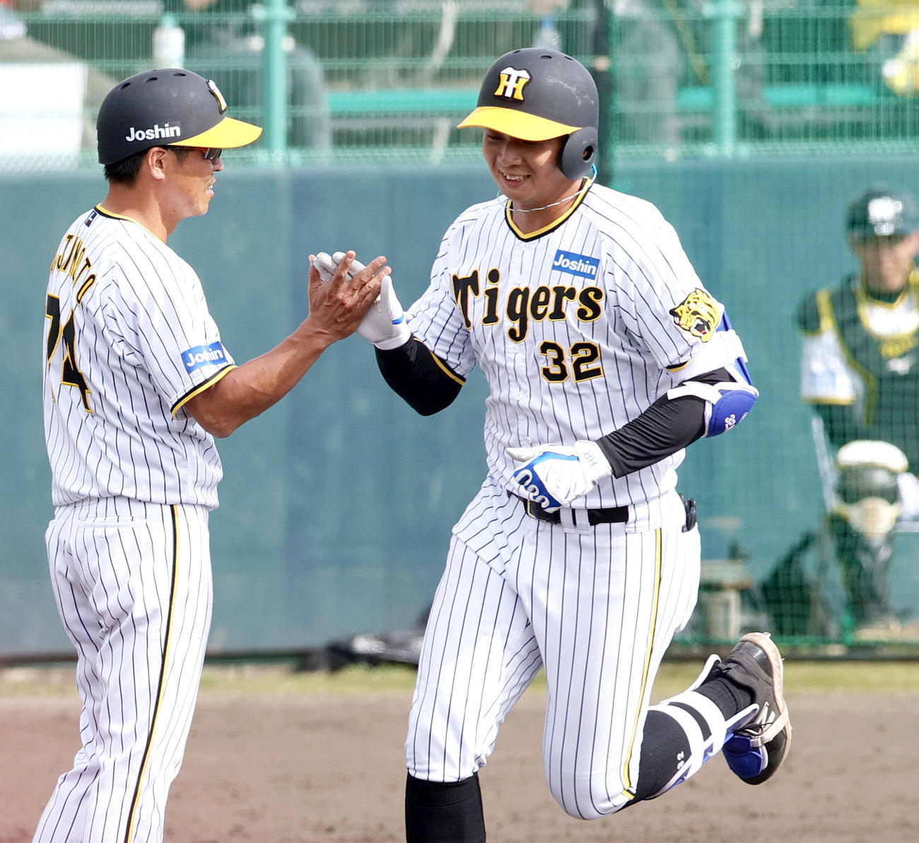 練習試合・阪神対サムスン　7回裏阪神2死満塁、井上（右）は左越え満塁本塁打を放ち藤本内野守備走塁コーチと笑顔でタッチを交わす（撮影・上山淳一）