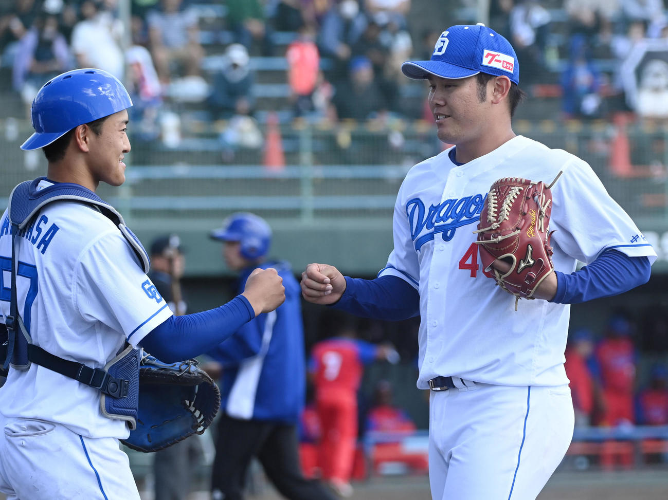 練習試合　中日対キューバ代表　5回表キューバ代表攻撃終了、山浅とタッチを交わしベンチへ戻る中日先発の鈴木（右）（撮影・森本幸一）