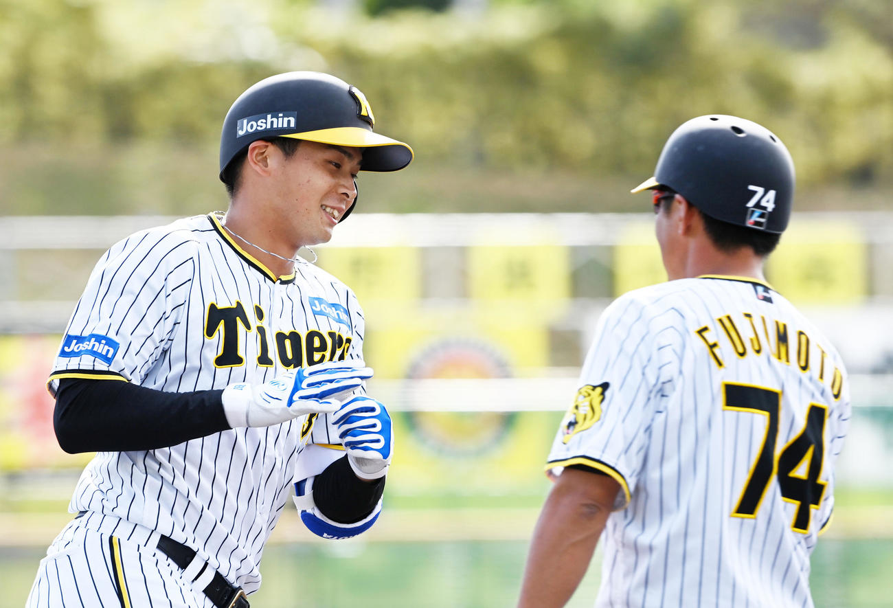 阪神対サムスン　7回裏阪神1死満塁、井上は左中間に満塁本塁打を放ち藤本コーチの祝福に笑顔を見せる（撮影・前岡正明）